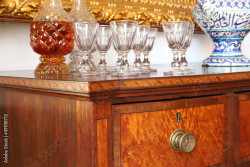 This is an isolated image of an antique Massachusetts server with antique glass decanters and wine glasses.