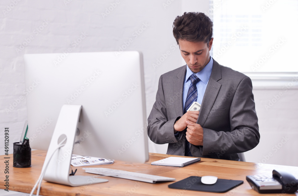 Pocketing some cash. A young businessman putting cash in his pocket. Pocketing some cash. A young businessman putting cash in his pocket.