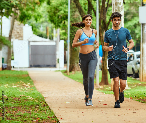 En route towards conquering their fitness goals. Shot of a sporty young couple exercising together outdoors.