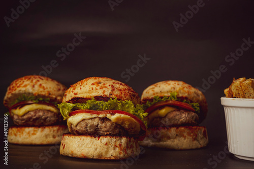 Three mini burgers on black background