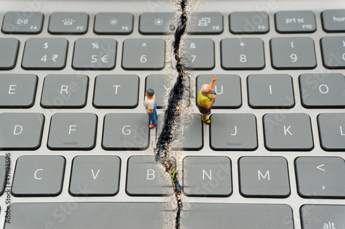 Internet Confrontation.digital divide.The keyboard is split by the cracks that separate the opposites.Social Divide.Divided world.conflicts.cyberbullying. photo
