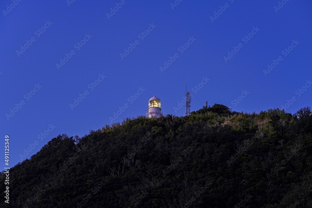 星空バックに海岸から見上げる室戸岬灯台の夜景＠高知