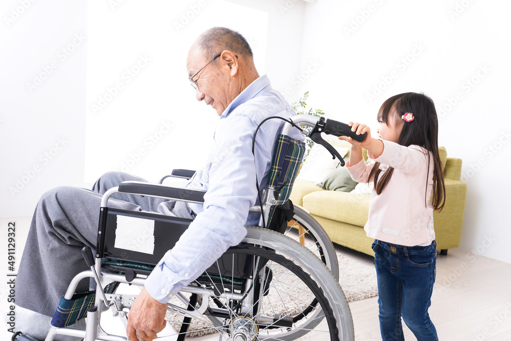 車椅子に乗る高齢男性と女の子