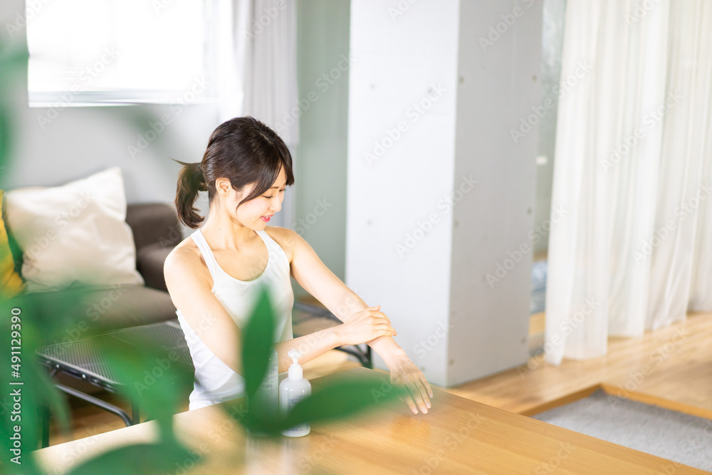 腕にクリームを塗る若い女性 腕にクリームを塗る若い女性
