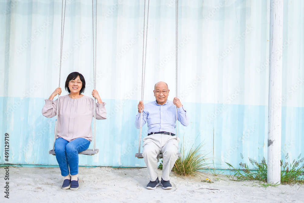 Fototapeta premium 夫婦でブランコに乗るシニア