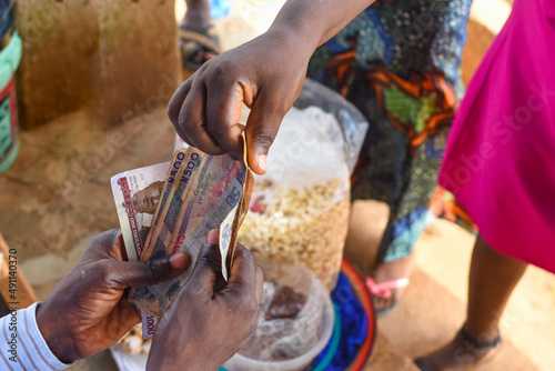 Cash, money or Nigerian currency exchanging hands during a business transaction with edible food in the background