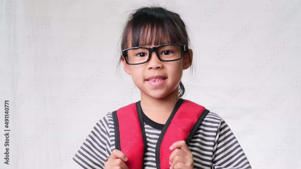 Cute schoolgirl wearing glasses with backpack , she nice-looking, charming and enjoying a good mood on white background in studio. Back to school concept Cute schoolgirl wearing glasses with backpack , she nice-looking, charming and enjoying a good mood on white background in studio. Back to school concept