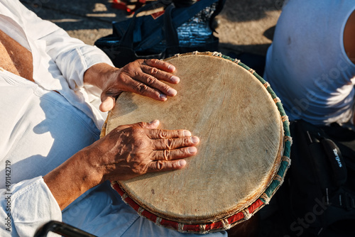 Hands of an African American man playing percussion with djembe drum bongo