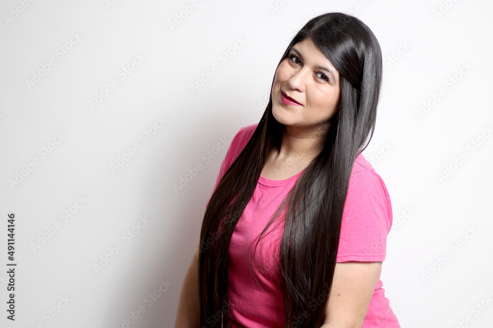 Fototapeta premium Latin adult woman poses for the camera showing her long straight black hair, healthy, shiny and silky hair looks happy and excited an overweight model body positive 