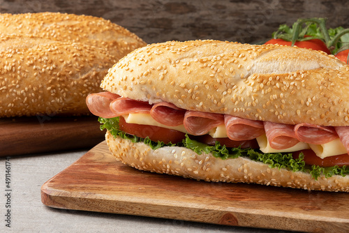 Baguette stuffed with salami, cheese, tomato and lettuce.