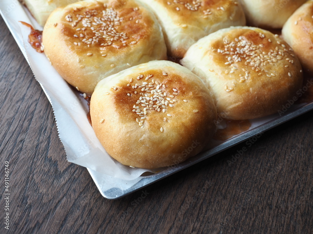 bread bun with sesame seed topping in baking tray bread bun with sesame seed topping in baking tray