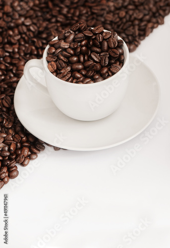 Drinking coffee is like taking my vitamins - my body needs it. Closeup shot of a cup filled with coffee beans against a half-and-half background.