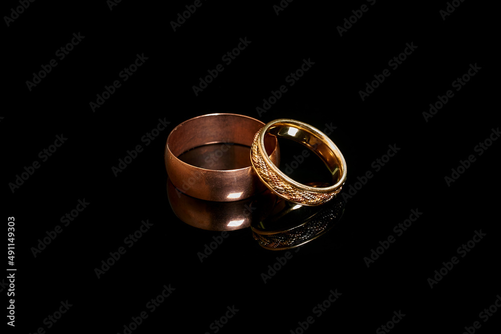 Two gold wedding rings on a black background Two gold wedding rings on a black background
