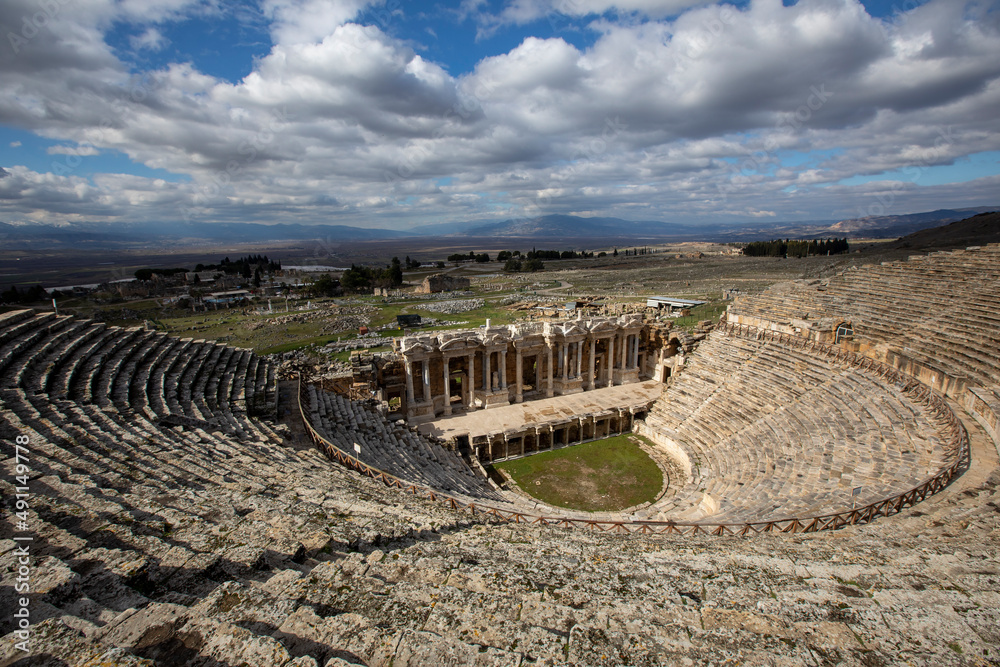 Amphitheater in ancient city of the Hierapolis. Dramatic sunset sky. Unesco Cultural Heritage Monument. Pamukkale, Turkey