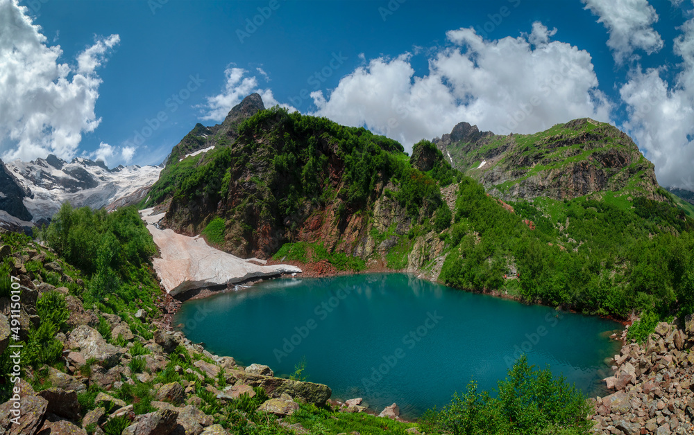 High-mountain lake in summer surrounded by mountain peaks, Dombai, Russia