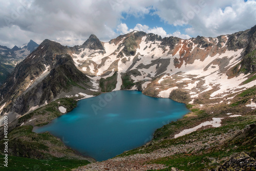 Fototapeta Naklejka Na Ścianę i Meble -  High-mountain lake in summer surrounded by mountain peaks, Dombai, Russia