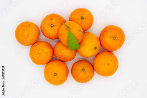 Few ripe tangerines with green leaves