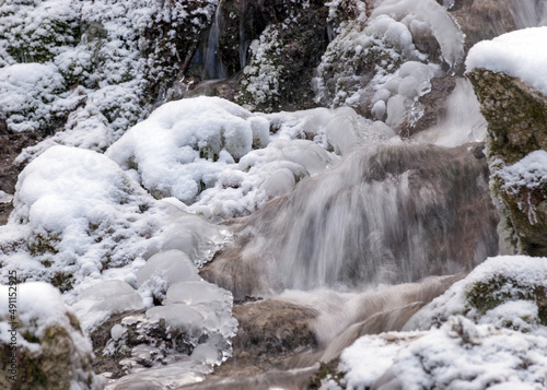 contrasts of frozen and running water, spring water flows over pieces of limestone, running water freezes to form various beautiful shapes © ANDA