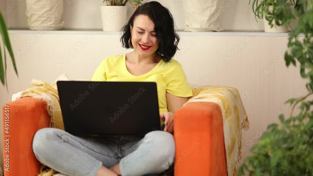 Positive woman watching video on laptop and laughing from joke Positive woman watching video on laptop and laughing from joke