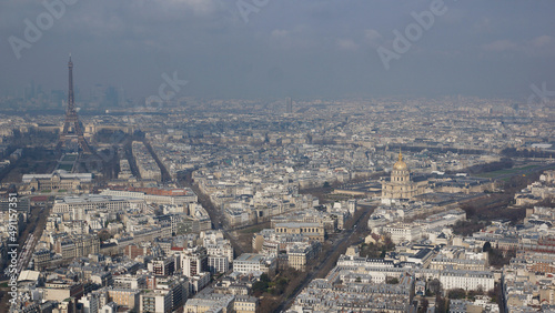 Ausblick vom Tour de Montparnasse auf den Eiffelturm und den Invalidendom sowie die Dächer von Paris von oben mit kleinen Wolken