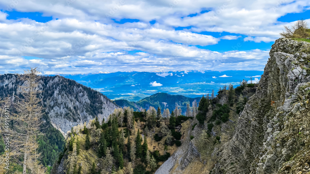 Panoramic view in spring near Frauenkogel on mountain peaks in the Karawanks, Carinthia, Austria. Borders Austria, Slovenia, Italy. Triglav National Park. Alpine meadows. Alm. Snow fields melting