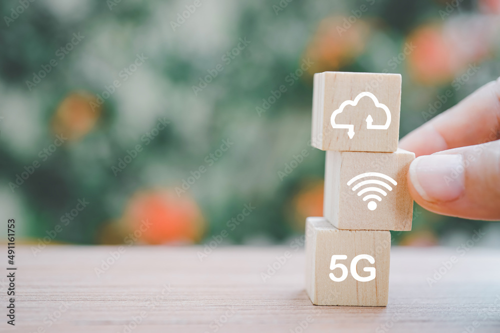 hand choose wooden cube block with wifi icon on wood table and blurred nature background for technology, networking concept hand choose wooden cube block with wifi icon on wood table and blurred nature background for technology, networking concept