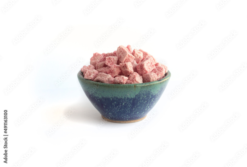 Pink Freeze Dried Yogurt or Yoghurt Cubes in Blue Pottery Bowl Isolated on White Pink Freeze Dried Yogurt or Yoghurt Cubes in Blue Pottery Bowl Isolated on White