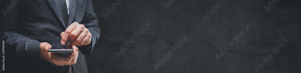 Panoramic image of handsome businessman using smartphone for business communication