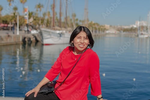 Happy latin girl on vacation in the port of Barcelona (Spain).