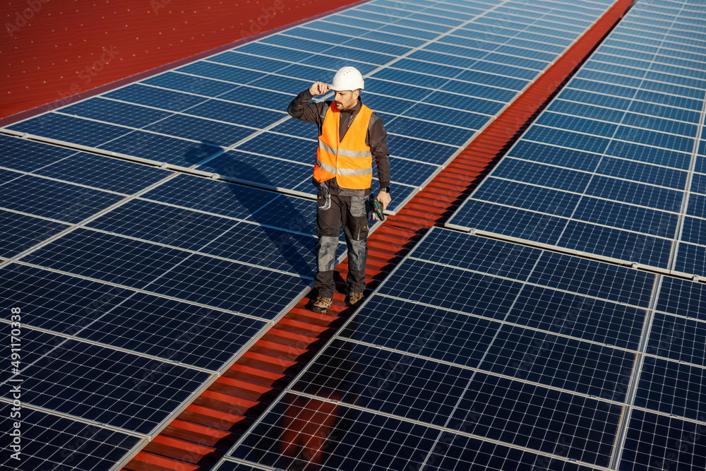 A handyman preparing to maintain solar panels on the rooftop. A handyman preparing to maintain solar panels on the rooftop.