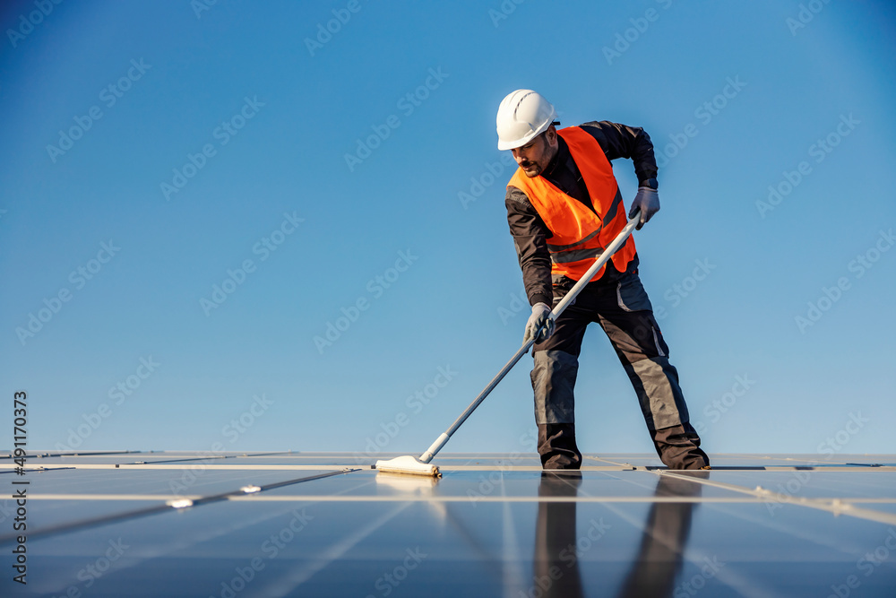 A worker maintain solar panel on the roof.
