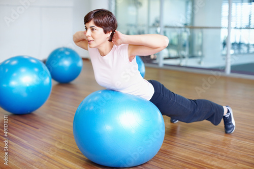 Fitness exercise. Woman doing fitness exercise using pilates ball.