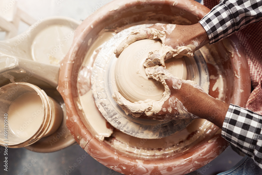 Fototapeta premium Experienced male potter working on pottery wheel