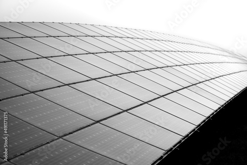 Solar cell panels mounted in a framework on a hilltop in Germany. Sunlight as a source of energy to generate direct current electricity – ecologic renewable power. Black and white greyscale gradient. photo