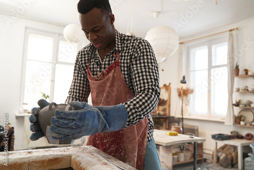 Fotografi Potter preparing earthenware vessel for bisque firing
