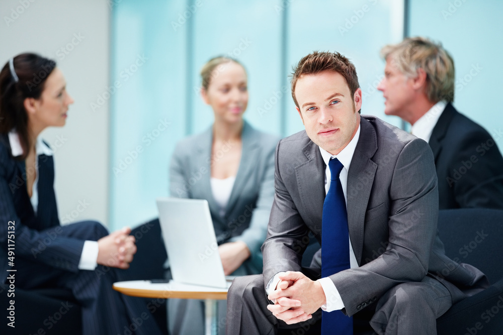 Confident business man with other executives. Portrait of confident business man with executives discussing in background. Confident business man with other executives. Portrait of confident business man with executives discussing in background.