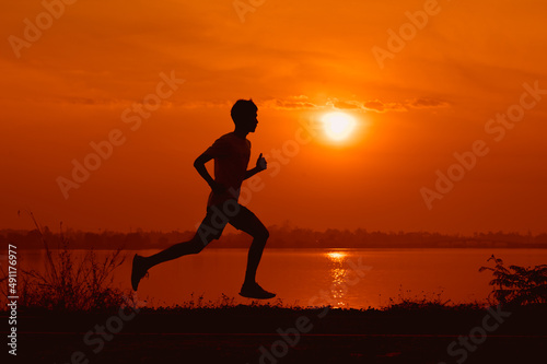 Fototapeta Naklejka Na Ścianę i Meble -  young male runner while practicing running On the road around the park around Thawatchai Reservoir Roi Et Province