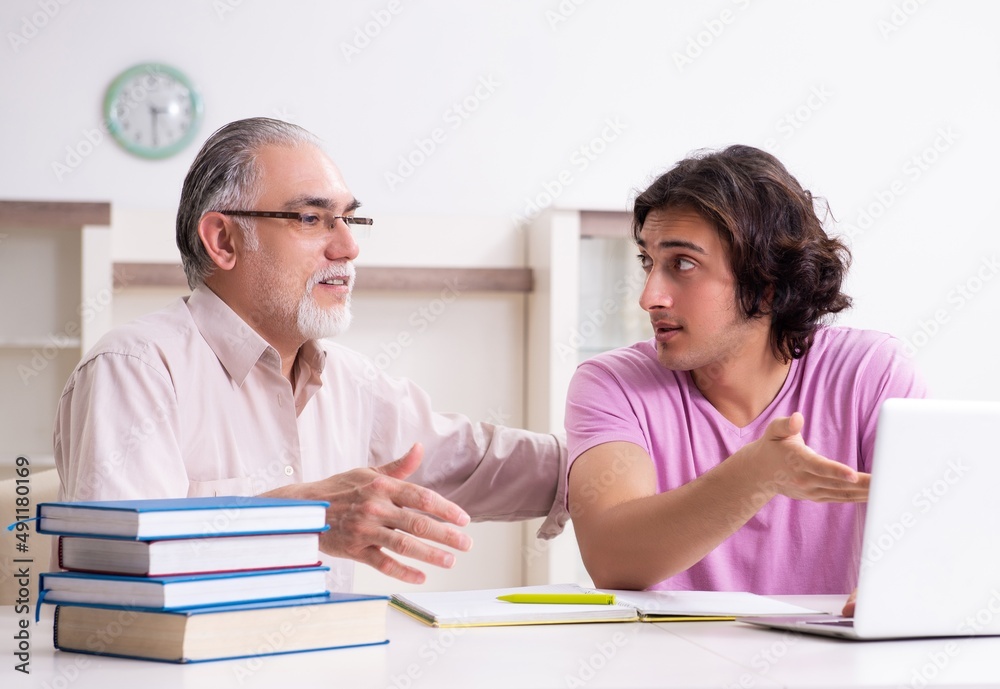 Old father helping his son in exam preparation Old father helping his son in exam preparation