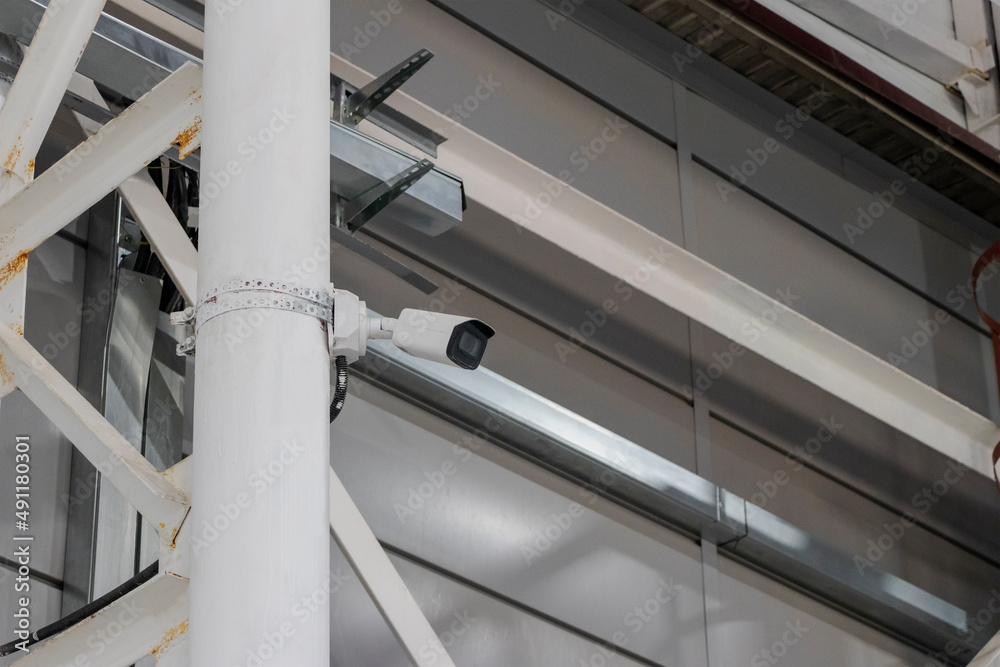 CCTV camera in an industrial workshop. Camera for monitoring workers and the production process. CCTV camera in an industrial workshop. Camera for monitoring workers and the production process.