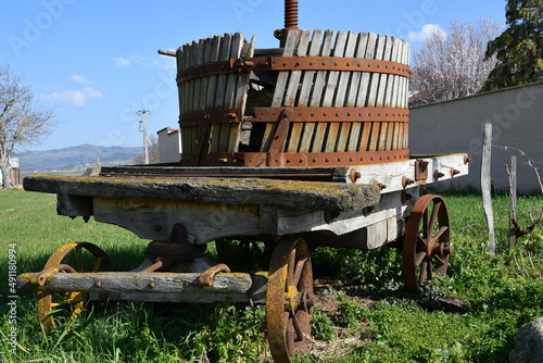 Vieux pressoir à raisin sur un chariot de bois à l'entrée d'un petit village vigneron en Auvergne par une belle journée de printemps photo