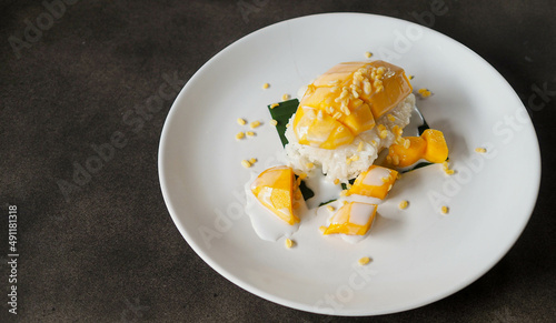 Ripe Mango Sticky Rice with Coconut Milk Authentic Thai desserts, Thai desserts./Mango Sticky Ricein restaurant style in plates with green banana leaves under natural light