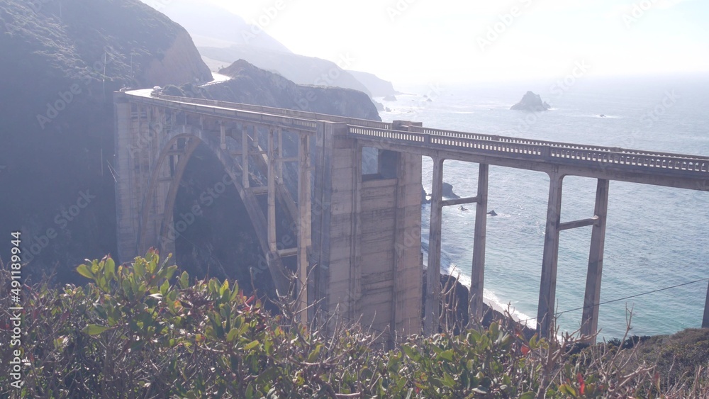 Obraz premium Bixby creek bridge, arch architecture. Pacific coast highway 1 landmark. Historic scenic Cabrillo road. Coastal road trip, journey or travel by ocean. Canyon in foggy weather. California, Big Sur, USA