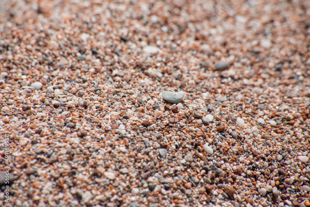 Small sea pebbles with stones with a reddish tint