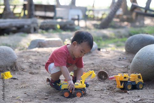 Little boy plays in the dirt with toy cars. The ultimate playground for boys. © Bonn