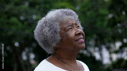 A contemplative black senior woman closing eyes in meditation