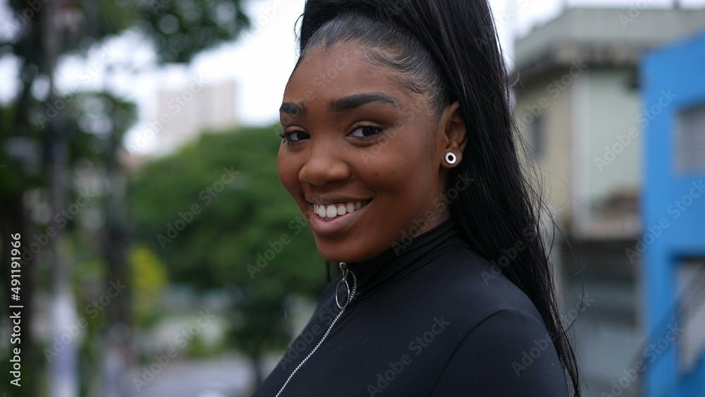 A Brazilian girl turning head to camera smiling while walking in street A Brazilian girl turning head to camera smiling while walking in street
