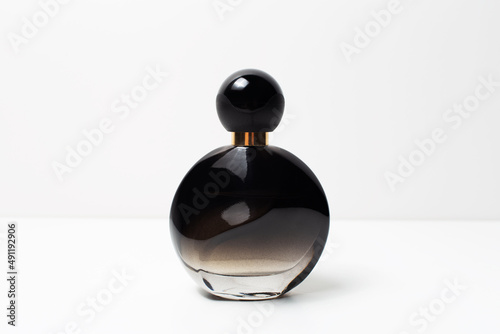 Close-up of black perfume bottle on white background.