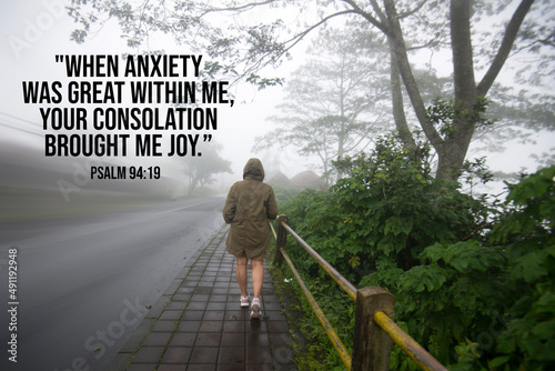Bible verse inspirational quote - When anxiety was great within me, your consolation brought me joy. Psalm 94:19 With person walking on the road, forest side on a misty morning.