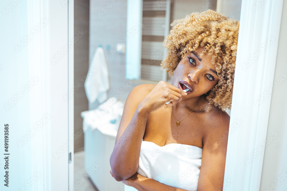 African american woman brushing her teeth using tooth brush and oral paste, cleaning teeth and tongue as healthy health care morning routine. Woman brushing her teeth with a toothbrush African american woman brushing her teeth using tooth brush and oral paste, cleaning teeth and tongue as healthy health care morning routine. Woman brushing her teeth with a toothbrush
