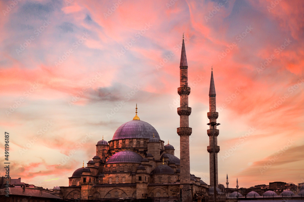Fototapeta premium Mosque minaret stretching into the sky, Photo taken from the side at sunset. New mosque Eminonu Turkey.